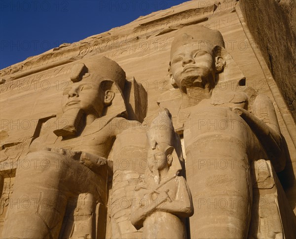 EGYPT, Nile Valley, Abu Simbel, Temple of Ramses II dedicated to the gods Haramakis Amon Ra and Ptah.  Detail of stone colossi.