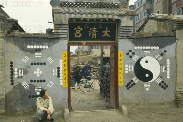 MONGOLIA, Religion, Buddhism, Yin and Yang painting on wall with woman sat on ground looking up at it