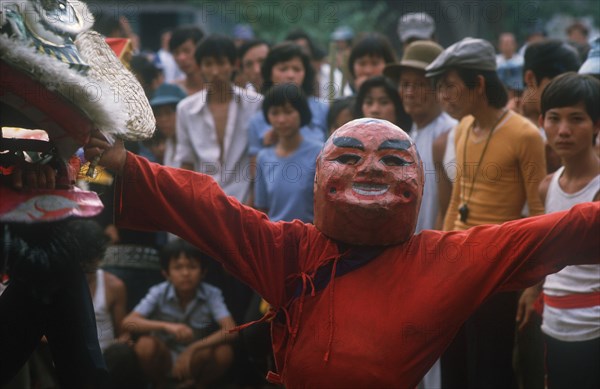 VIETNAM, Ho Chi Minh City , Ton San Village.  Dancer wearing carnival head at Tet dance celebrating the Vietnamese New Year.