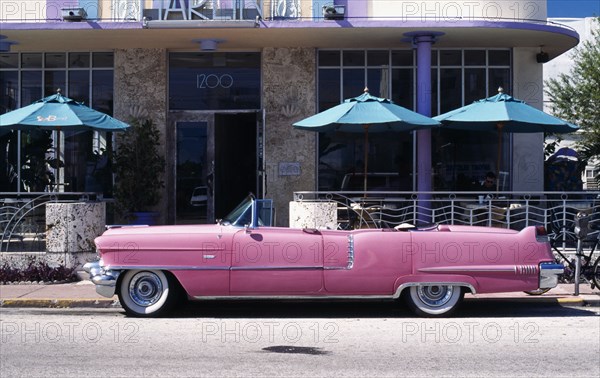 USA, Florida, Miami, Ocean Drive. Pink Cadillac parked outside Art Deco style Marlin Hotel on South Beach.