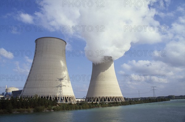 FRANCE, Champagne Ardenne, Aube, "Nogent, Seine Valley.  Nuclear power station cooling towers beside water, emitting smoke"