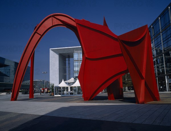 FRANCE, Ile de France, Paris, La Défense. La Grande Arche framed by red modern sculpture.