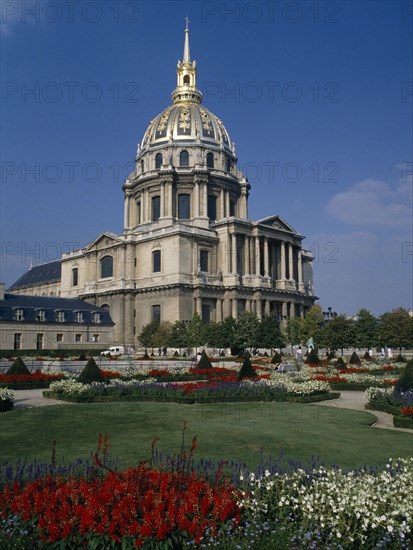 FRANCE, Ile de France  , Paris, "Hotel des Invalides, exterior with red, white and purple flowers in foreground."