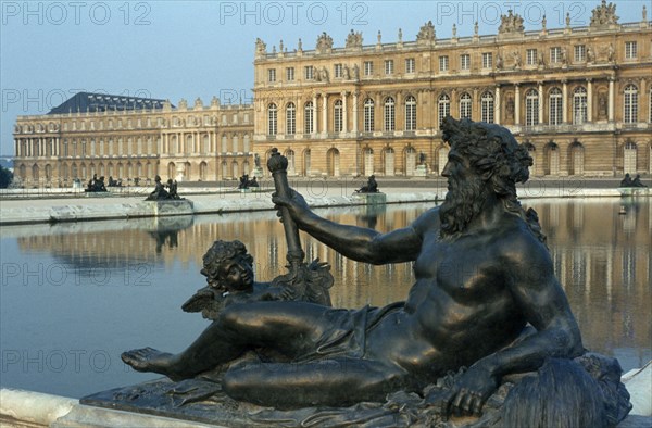 FRANCE, Ile de France, Versailles, Palace with lake and statue of reclining figure in foreground.