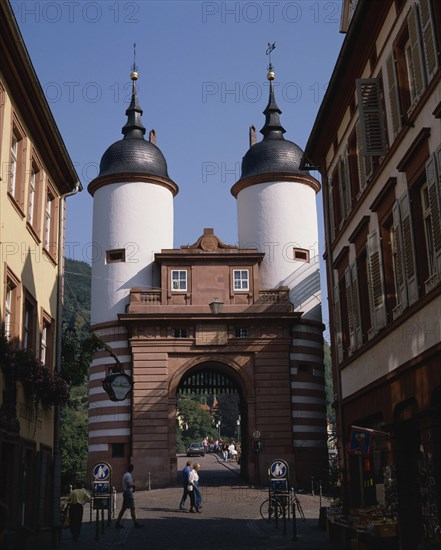 GERMANY, Bad Wurttemberg, Heidelberg, The Bridge Gate with white twin towers and black domes on a cobbled street