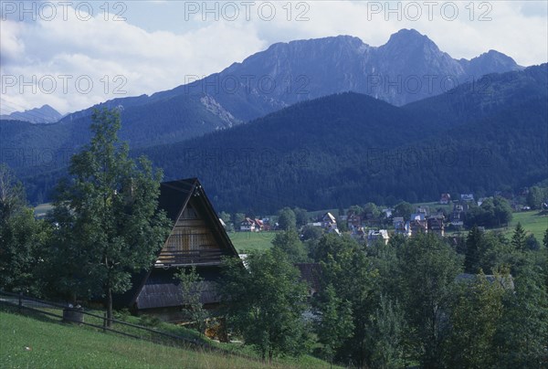POLAND, Tatra, Tatra Mountain range with wooden chalet roof in the foreground.