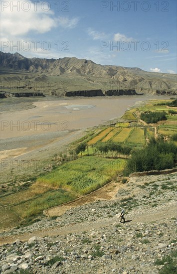 CHINA, Qinghai, Guide, Yellow River with agricultural land in foreground and rugged landscape on the opposite bank