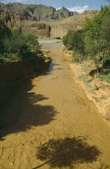 CHINA, Yellow River , View over rapid flowing silt laden water toward main river