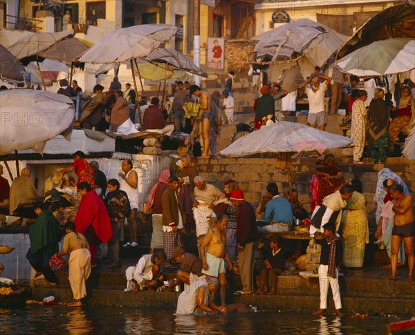 INDIA, Uttar Pradesh , Varanasi, The ghats at dawn with crowds of people washing in the River Ganges.