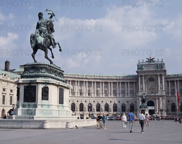 AUSTRIA, Lower Austria, Vienna, Hofburg Palace. Equestrian statue on plinth standing in courtyard outside semi circular facade with passing people.