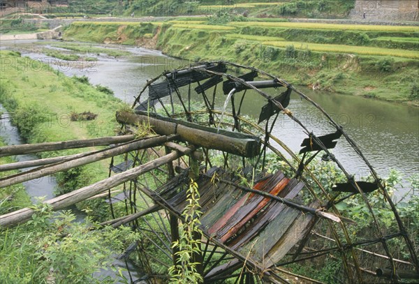 CHINA, Guangxi, Bamboo water wheel on the edge of a river.