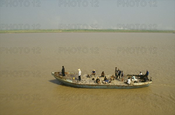 CHINA, Henan, Near Zengzhou, Rusty passenger ferry sailing along the Yellow River