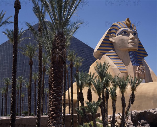 USA, Nevada, Las Vegas, Luxor Hotel and Casino Pyramid shaped building with replica of sphinx beside palm trees