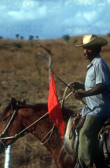CUBA, Sancti Spiritus, Man on horseback carrying red flag