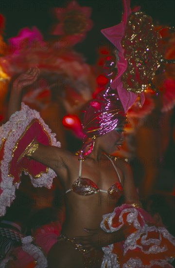 CUBA, Havana Province, Havana, Tropicana Club female dancer in pink costume in front of other dancers