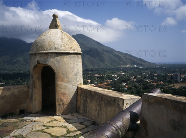 VENEZUELA, Margarita Island, La Asuncion, "Santa Rosa Fort, corner of crenellated battlements with a cannon.  View towards mountains beyond."