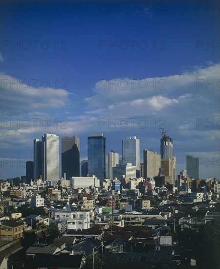 JAPAN, Honshu, Tokyo, View over city rooftops with high-rise buildings and skyscrapers in the background