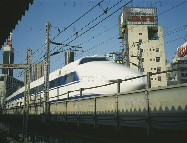JAPAN, Honshu, Tokyo, Shinkansen Bullet Train speeding along raised railway line in the centre of Tokyo