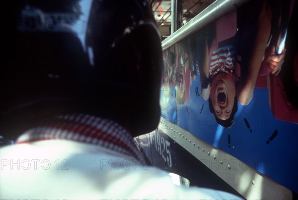 THAILAND, Transport, View from the back of a motorbike over the helmet of the driver and along the side of a bus in a traffic jam