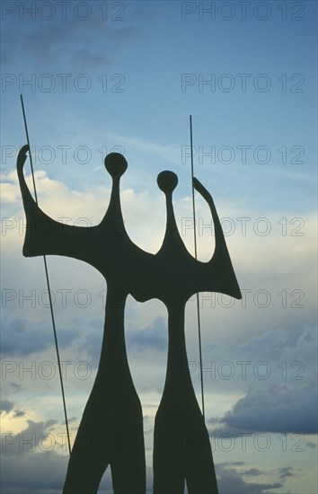 BRAZIL, Federal District, Brasilia, "Os Candangos, or The Warriors, sculpture by Bruno Giorgi silhouetted at dusk."