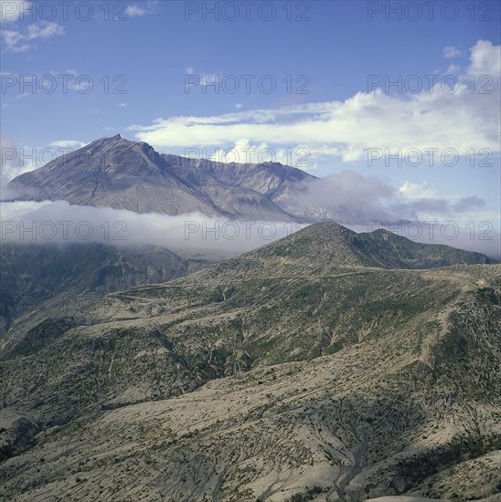 USA, Washington, Mount St Helens, The volcano shrouded in cloud after the eruption with the devastated landscape below