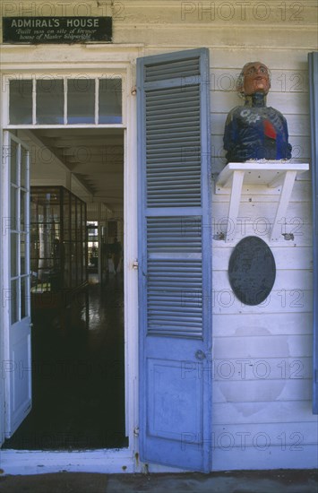 WEST INDIES, Antigua, Nelson’s Dockyard, Admirals House doorway with wooden carving of naval officer on the wall
