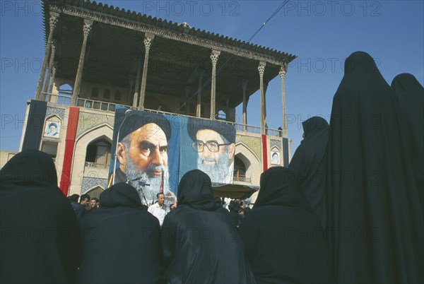 IRAN, Esfahan, Banners of Ayatollah Khomeini and Ali Khamenei to commemorate death of Emam Hussain with outlines of women in black in the foreground  Isfahan