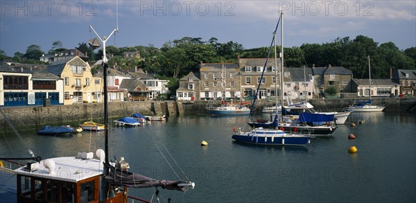 ENGLAND, Cornwall, Padstow , View across the harbour with fishing boats and yachts towards waterside buildings