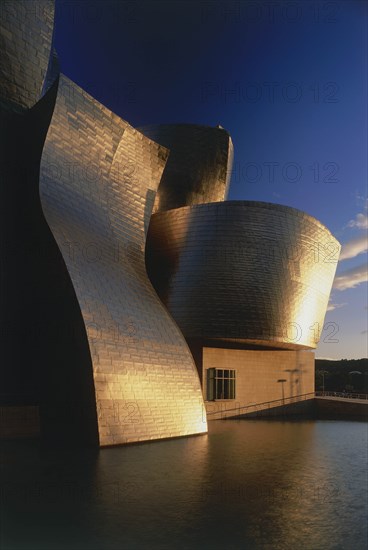 SPAIN, Basque Province, Bilbao, The Guggenheim Museum deatail with golden sunshine reflected at sunset