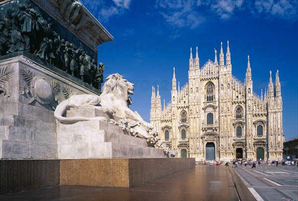 ITALY, Lombardy, Milan, The Duomo with stone statue of lion on plinth in the foreground.