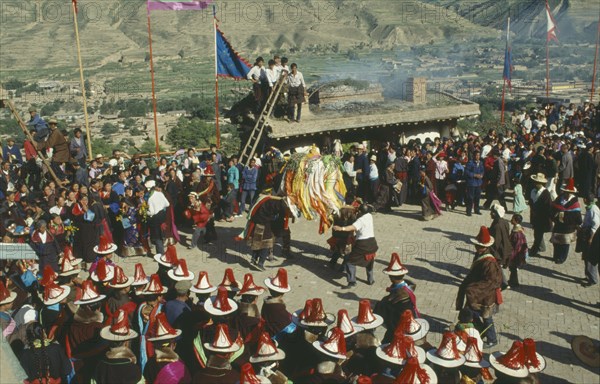 CHINA, Quinghai, Tongren, Tibetan festival with people wearing red tassled hats