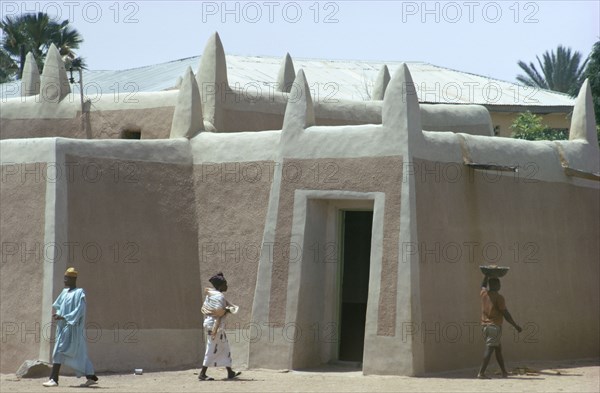 MALI, Djenne, NOT IN LIBRARY Traditional Building with local people walking by