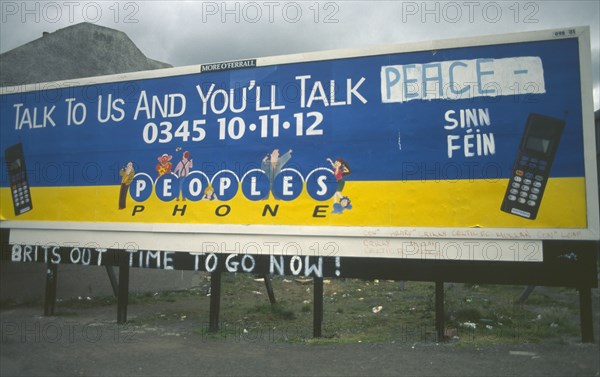IRELAND,  North , Belfast, "Peoples Phone billboard advertisment poster on Falls Road dawbed with Sinn Fein grafitti, Belfast"