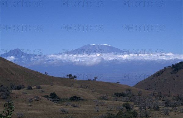 TANZANIA, Mount Kilimanjaro, View over landscape toward Kilimanjaro Volcano with the summit visible above the clouds