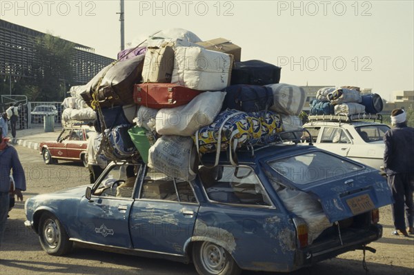 EGYPT, Aswan, Sudanese family in overloaded car waiting for ferry to Sudan