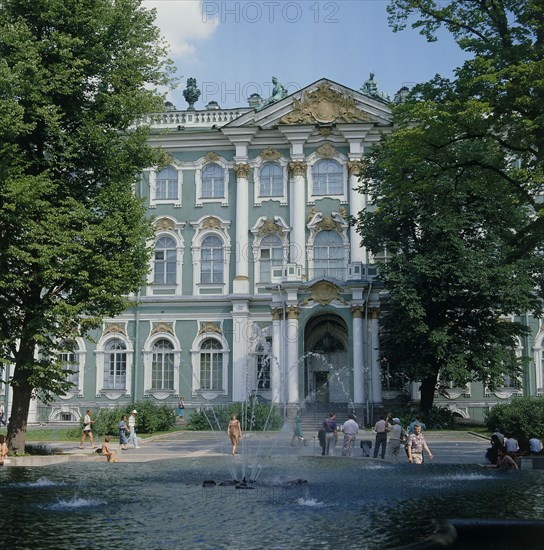 RUSSIA, St Petersburg, Hermitage Palace and gardens with fountain and people walking