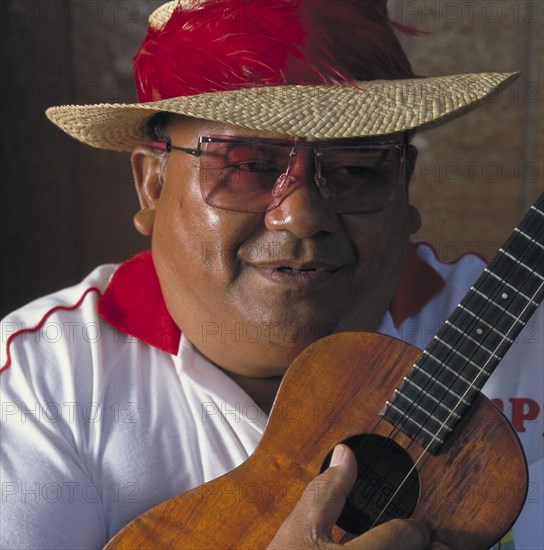 USA, Hawaii, People, Man wearing straw hat playing a ukulele