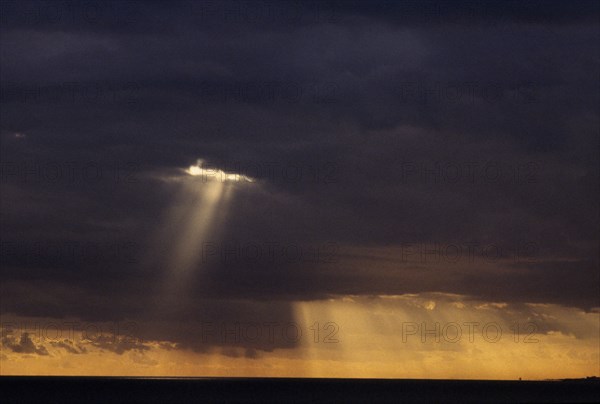 WEATHER, Climate, Clouds, Sun rays breaking through thick grey cloud.