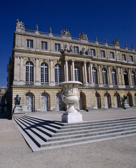FRANCE, Ile de France , Yvelines-Versa, "Versailles. Part view of palace with steps and white urn, arched windows and blue sky "