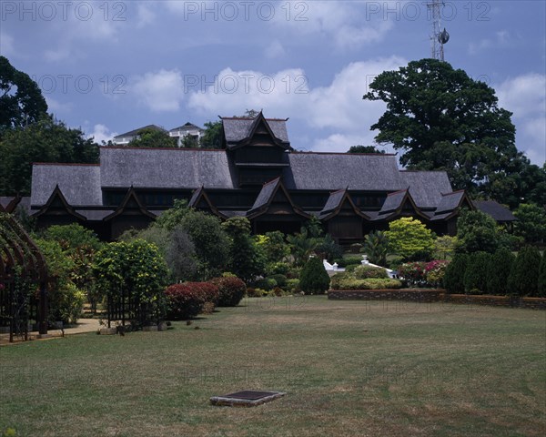 MALAYSIA, East Coast, Malacca, The Sultans Palace viewed from across green lawn with flowers and bushes with pathway and white steps