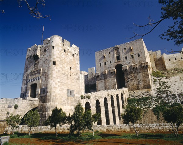 SYRIA, North, Aleppo, The Citadel. Exterior of stone fortification and arched viaduct between towers