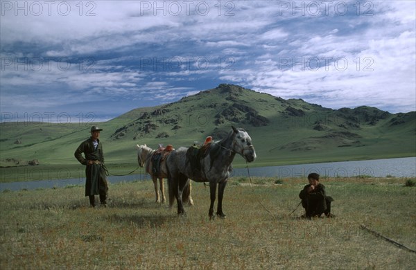 MONGOLIA, Arkhangai, Tsaagan Nuur, Two horsemen with horses not on horseback