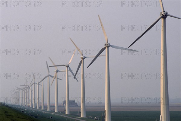 HOLLAND, Urk, Wind generators in a line in a misty landscape