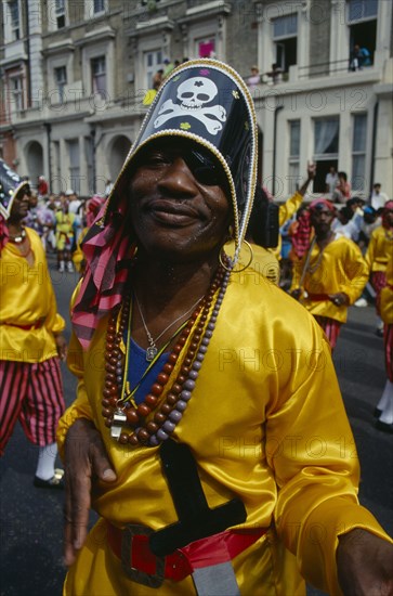 ENGLAND, London, Notting Hill Carnival man dressed as a pirate with yellow shirt and skull and crossbones hat