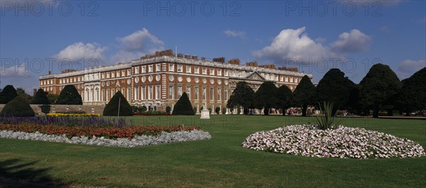 ENGLAND, London, Hampton Court Palace. General view seen across formal gardens