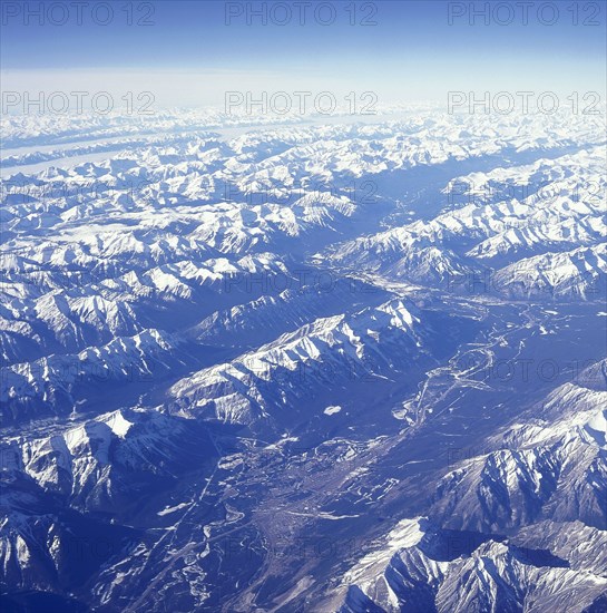 USA, Montana, Glacier National Park, The snow covered Rocky Mountains with a thin layer of cloud seen from above