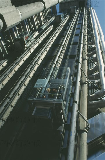 ENGLAND, London, View looking up at the lifts with pasengers on the exterior of the Lloyds building