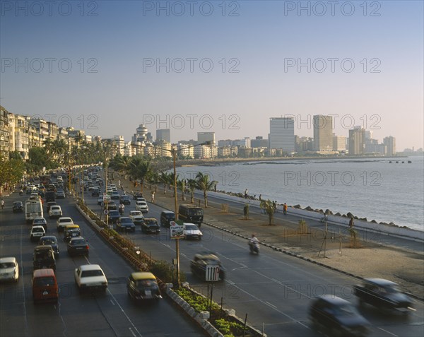 INDIA, Maharashtra, Bombay, "Marine Drive at dusk,cars on dual carriageway, skyscrapers beyond "