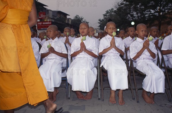 THAILAND, Chiang Mai, Novice monks holding lotus buds at ordination ceremony