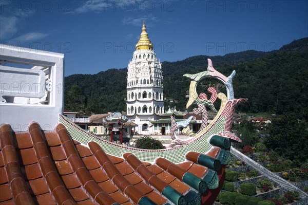 MALAYSIA, Penang, Kek Lok Si Temple, View over rooftop detail toward white tower with golden roof and spire